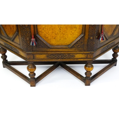 1561 - A late 19thC / early 20thC oak and walnut cabinet with an oak upstand, above blind fretwork carving ... 