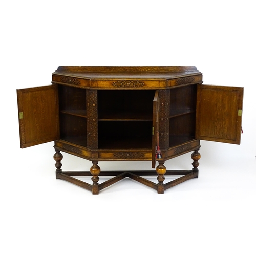 1561 - A late 19thC / early 20thC oak and walnut cabinet with an oak upstand, above blind fretwork carving ... 