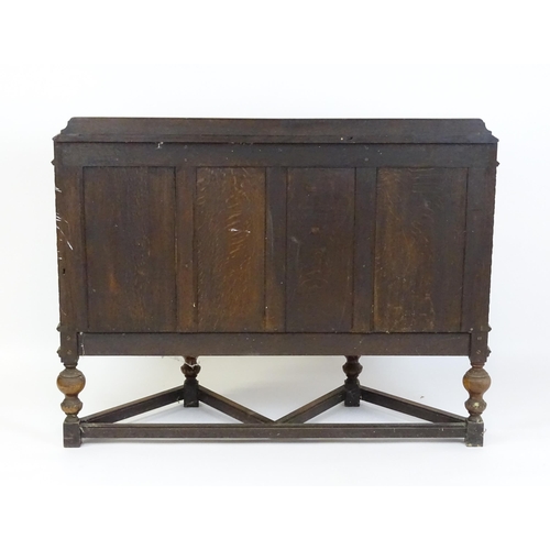 1561 - A late 19thC / early 20thC oak and walnut cabinet with an oak upstand, above blind fretwork carving ... 