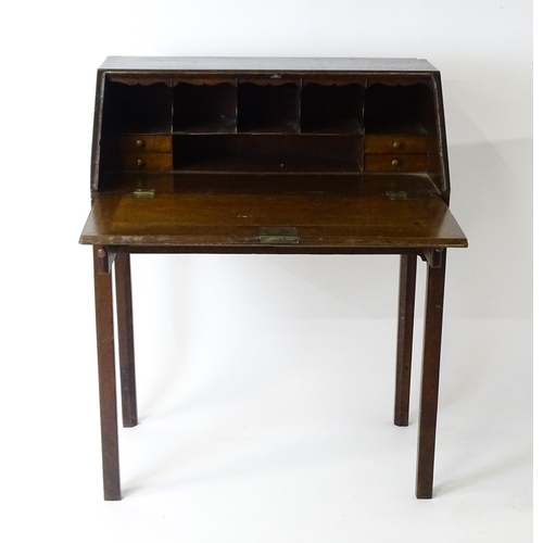 1562 - A late 18thC oak clerks desk with a fall front above two short drawers with swan neck handles and ra... 