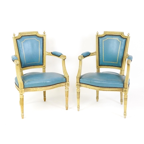 1574 - A pair of 20thC French Louis XVI armchairs, surmounted by turned finials and having gold tooled leat... 