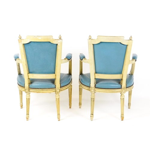 1574 - A pair of 20thC French Louis XVI armchairs, surmounted by turned finials and having gold tooled leat... 