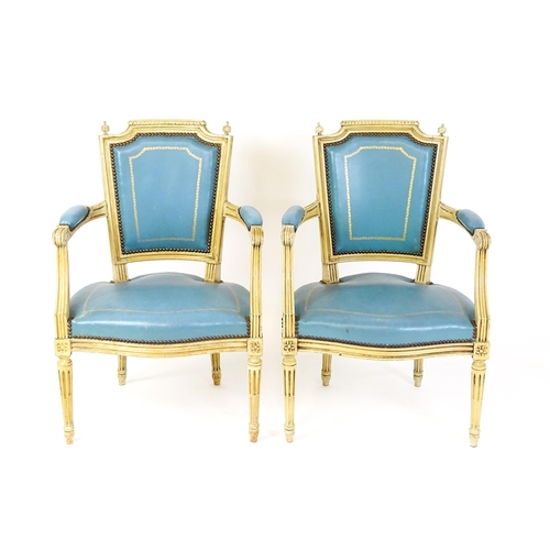 1574 - A pair of 20thC French Louis XVI armchairs, surmounted by turned finials and having gold tooled leat... 