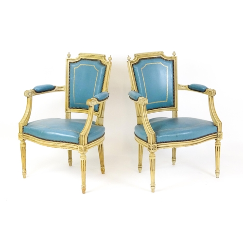 1574 - A pair of 20thC French Louis XVI armchairs, surmounted by turned finials and having gold tooled leat... 