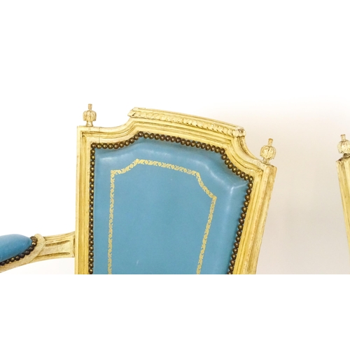 1574 - A pair of 20thC French Louis XVI armchairs, surmounted by turned finials and having gold tooled leat... 