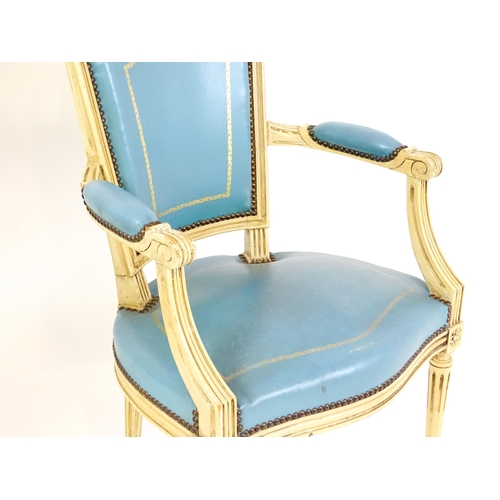 1574 - A pair of 20thC French Louis XVI armchairs, surmounted by turned finials and having gold tooled leat... 