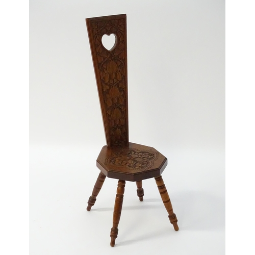 1624 - A late 19thC / early 20thC oak spinners chair with floral carved decoration and a pierced heart hand... 