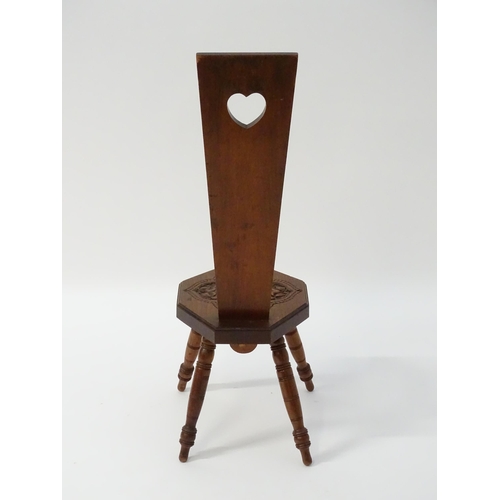 1624 - A late 19thC / early 20thC oak spinners chair with floral carved decoration and a pierced heart hand... 