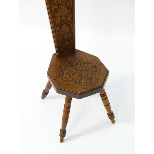 1624 - A late 19thC / early 20thC oak spinners chair with floral carved decoration and a pierced heart hand... 