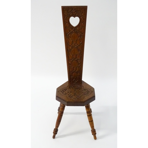 1624 - A late 19thC / early 20thC oak spinners chair with floral carved decoration and a pierced heart hand... 