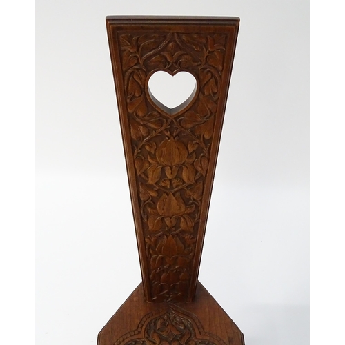 1624 - A late 19thC / early 20thC oak spinners chair with floral carved decoration and a pierced heart hand... 