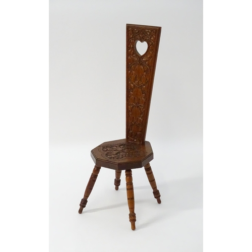 1624 - A late 19thC / early 20thC oak spinners chair with floral carved decoration and a pierced heart hand... 