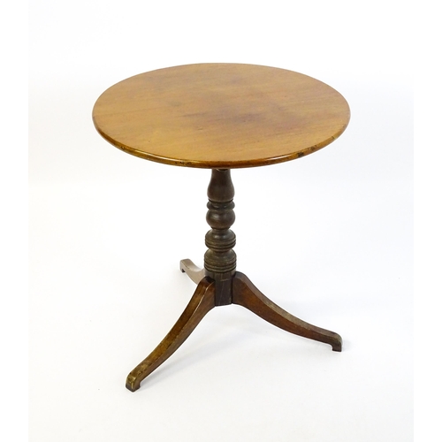 1633 - A 19thC mahogany tripod table with a circular top above a turned pedestal and three shaped legs. 25