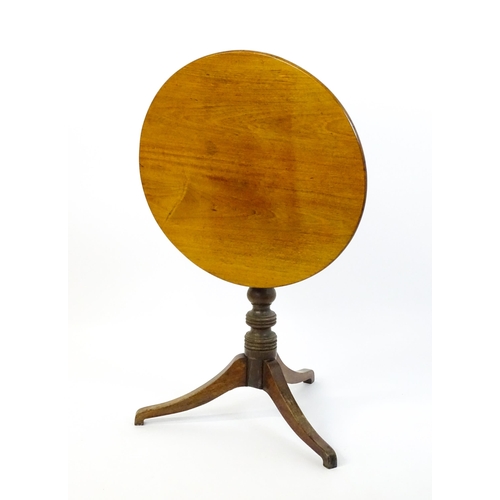 1633 - A 19thC mahogany tripod table with a circular top above a turned pedestal and three shaped legs. 25