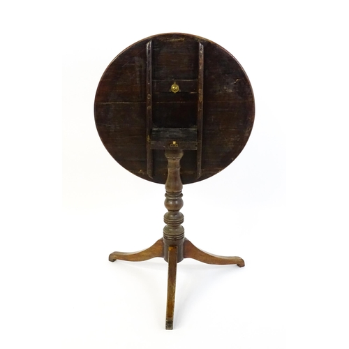 1633 - A 19thC mahogany tripod table with a circular top above a turned pedestal and three shaped legs. 25