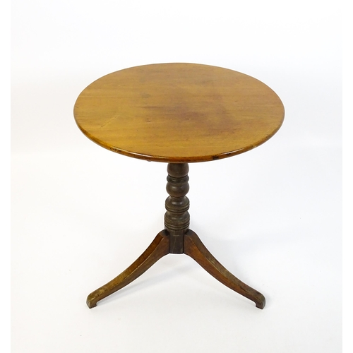 1633 - A 19thC mahogany tripod table with a circular top above a turned pedestal and three shaped legs. 25