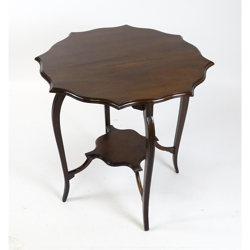 1635 - An Edwardian mahogany occasional table with a shaped, moulded top above four cabriole legs united by... 