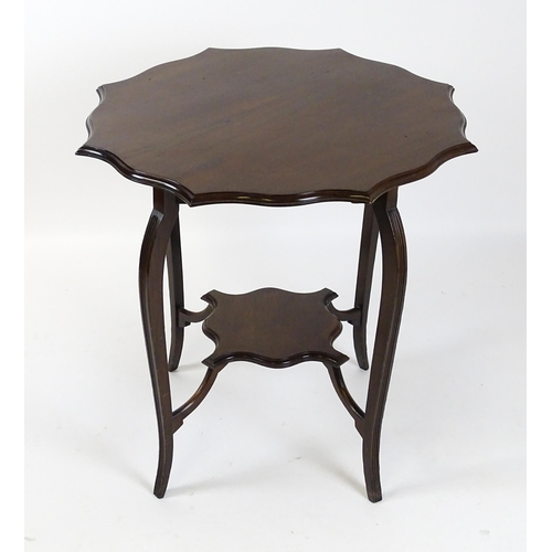 1635 - An Edwardian mahogany occasional table with a shaped, moulded top above four cabriole legs united by... 