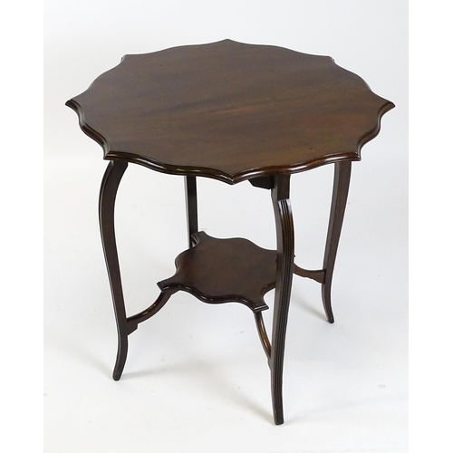 1635 - An Edwardian mahogany occasional table with a shaped, moulded top above four cabriole legs united by... 