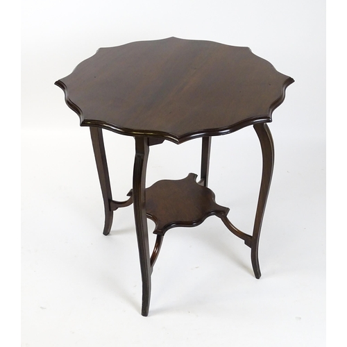 1635 - An Edwardian mahogany occasional table with a shaped, moulded top above four cabriole legs united by... 