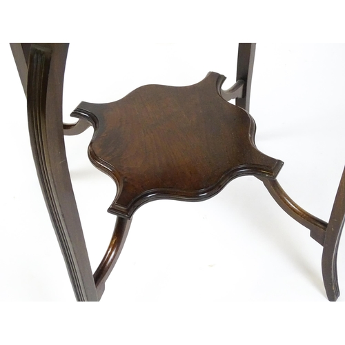 1635 - An Edwardian mahogany occasional table with a shaped, moulded top above four cabriole legs united by... 