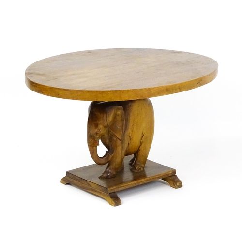 1639 - A mid 20thC teak occasional table with an oval top above an elephant formed pedestal and rectangular... 