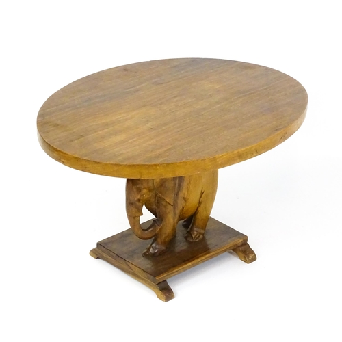 1639 - A mid 20thC teak occasional table with an oval top above an elephant formed pedestal and rectangular... 