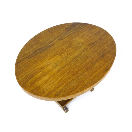 1639 - A mid 20thC teak occasional table with an oval top above an elephant formed pedestal and rectangular... 