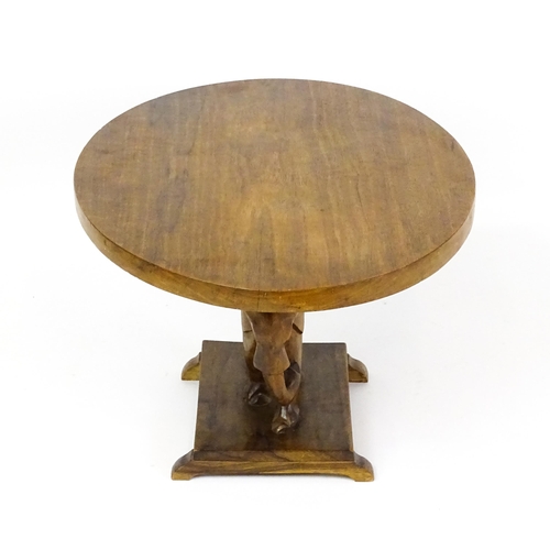 1639 - A mid 20thC teak occasional table with an oval top above an elephant formed pedestal and rectangular... 