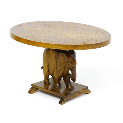 1639 - A mid 20thC teak occasional table with an oval top above an elephant formed pedestal and rectangular... 