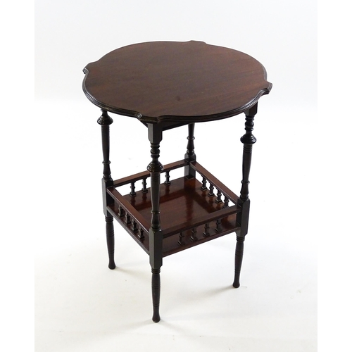 1640 - An Edwardian mahogany occasional table with a shaped top above a lower under tier with a turned gall... 