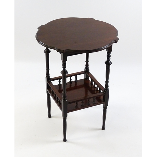 1640 - An Edwardian mahogany occasional table with a shaped top above a lower under tier with a turned gall... 