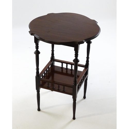 1640 - An Edwardian mahogany occasional table with a shaped top above a lower under tier with a turned gall... 