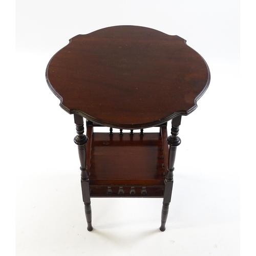 1640 - An Edwardian mahogany occasional table with a shaped top above a lower under tier with a turned gall... 