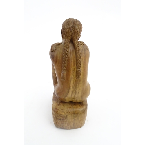 1118 - A 20thC carved wooden sculpture depicting a seated female nude. Signed S. Connor lower. Approx. 11