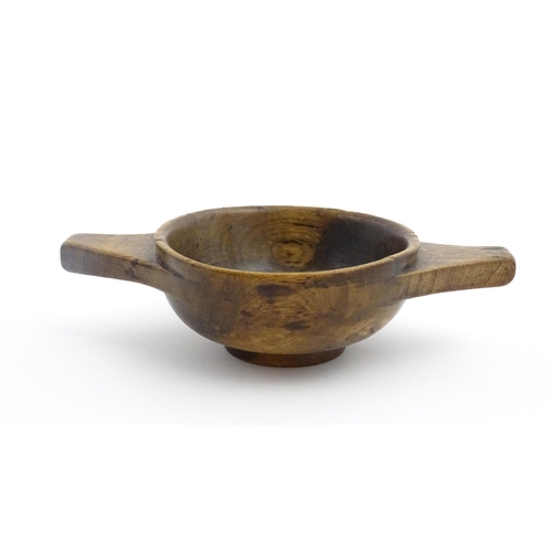 1128 - Treen : A 19thC Scottish turned wooden quaich. Approx. 4 3/4