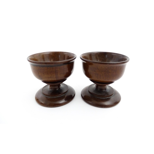 1181 - Treen : A pair of turned wooden salts of pedestal form. Approx. 2 1/4