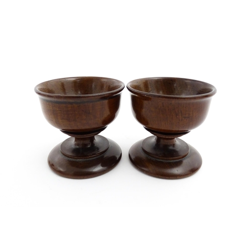 1181 - Treen : A pair of turned wooden salts of pedestal form. Approx. 2 1/4