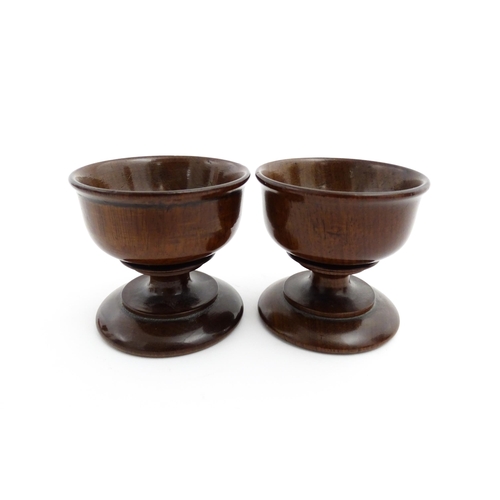 1181 - Treen : A pair of turned wooden salts of pedestal form. Approx. 2 1/4