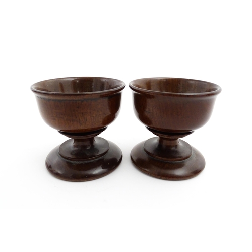 1181 - Treen : A pair of turned wooden salts of pedestal form. Approx. 2 1/4