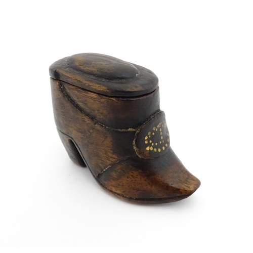 1197 - Treen : A 19thC Continental shoe snuff box of boot form with sliding lid and brass studwork detail t... 