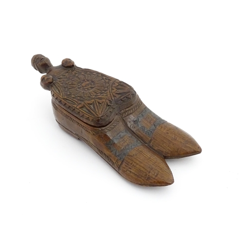 1200 - Treen : A 19thC shoe snuff box with chip carved decoration and carved figural detail to lid. Possibl... 