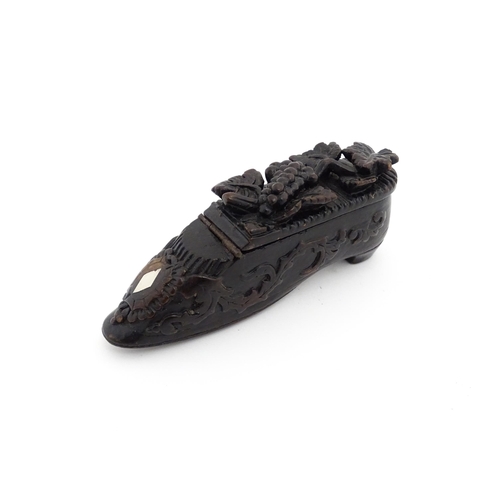 1207 - Treen : A 19thC Continental shoe snuff box with carved decoration, the hinged with fruiting vine det... 