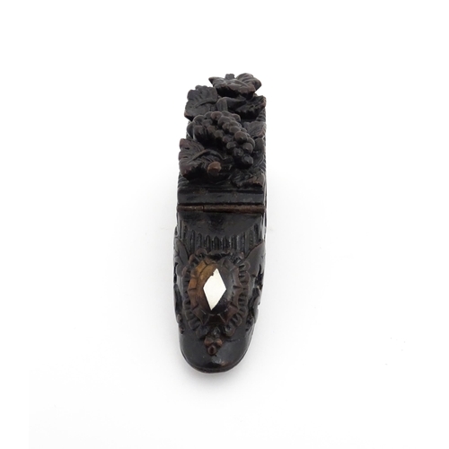 1207 - Treen : A 19thC Continental shoe snuff box with carved decoration, the hinged with fruiting vine det... 