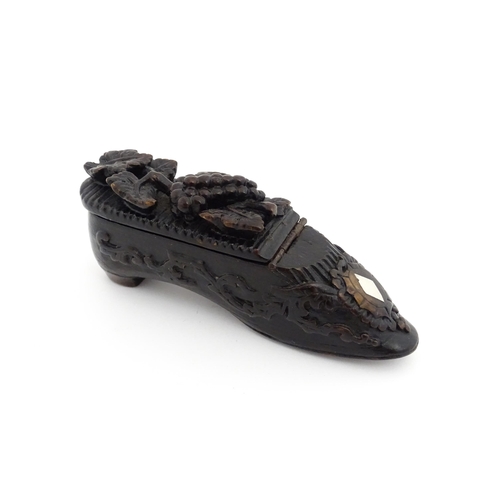 1207 - Treen : A 19thC Continental shoe snuff box with carved decoration, the hinged with fruiting vine det... 