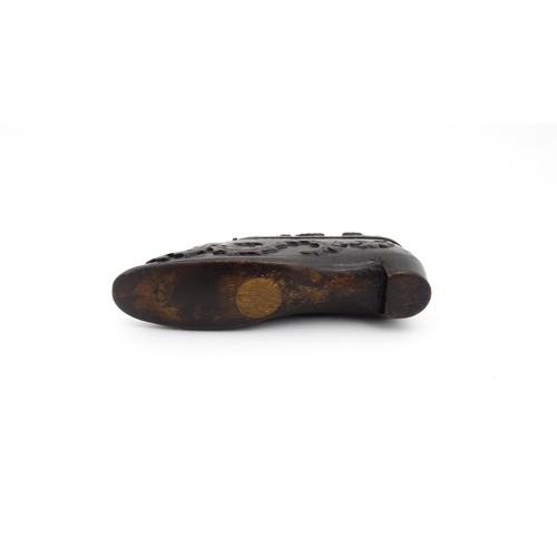 1207 - Treen : A 19thC Continental shoe snuff box with carved decoration, the hinged with fruiting vine det... 