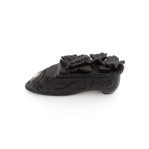 1207 - Treen : A 19thC Continental shoe snuff box with carved decoration, the hinged with fruiting vine det... 