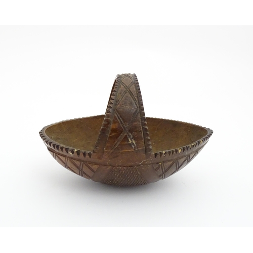 1210 - A 20thC carved coconut formed as a basket with geometric detail. Together with treen string box of b... 