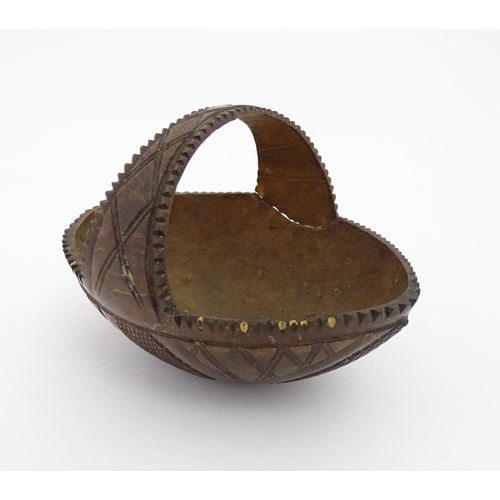 1210 - A 20thC carved coconut formed as a basket with geometric detail. Together with treen string box of b... 