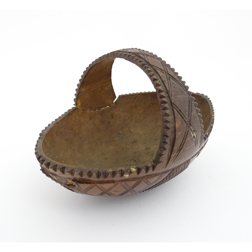 1210 - A 20thC carved coconut formed as a basket with geometric detail. Together with treen string box of b... 